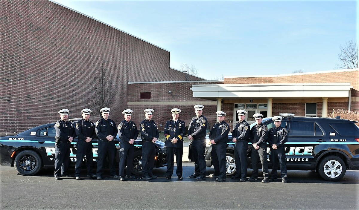 police officers standing in front of cars